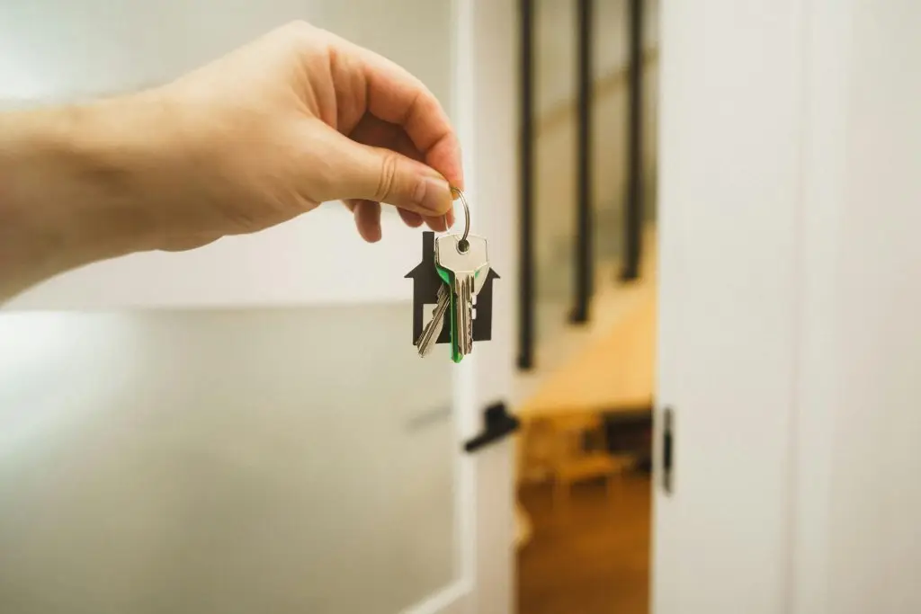 handing over the keys to new home real estate agent oen door